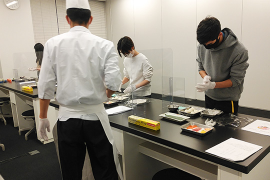 織田調理師専門学校の教員が参加者に調理をレクチャーしている様子